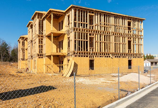 a close-up of temporary chain link fences enclosing a job site, signaling progress in the project's development in Milton